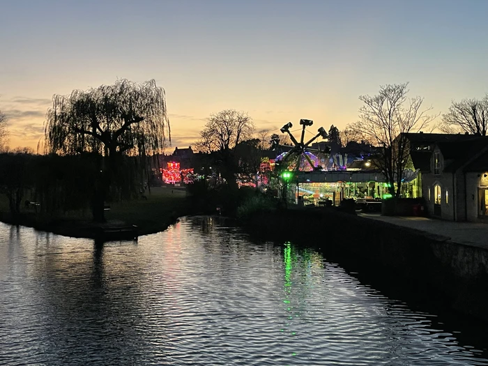 A view of the Mid-Lent Fair at night across the river from the town bridge in Stamford