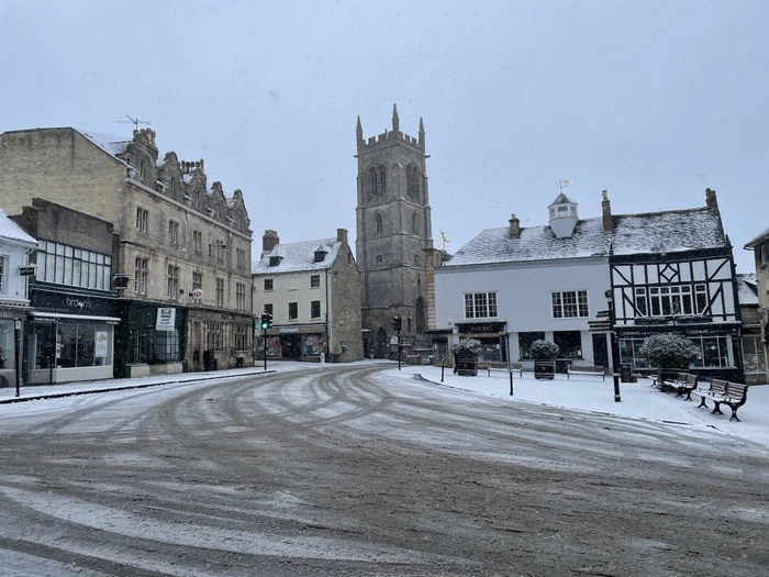 Snow falling on tyre tracks through Red Lion Square, Stamford